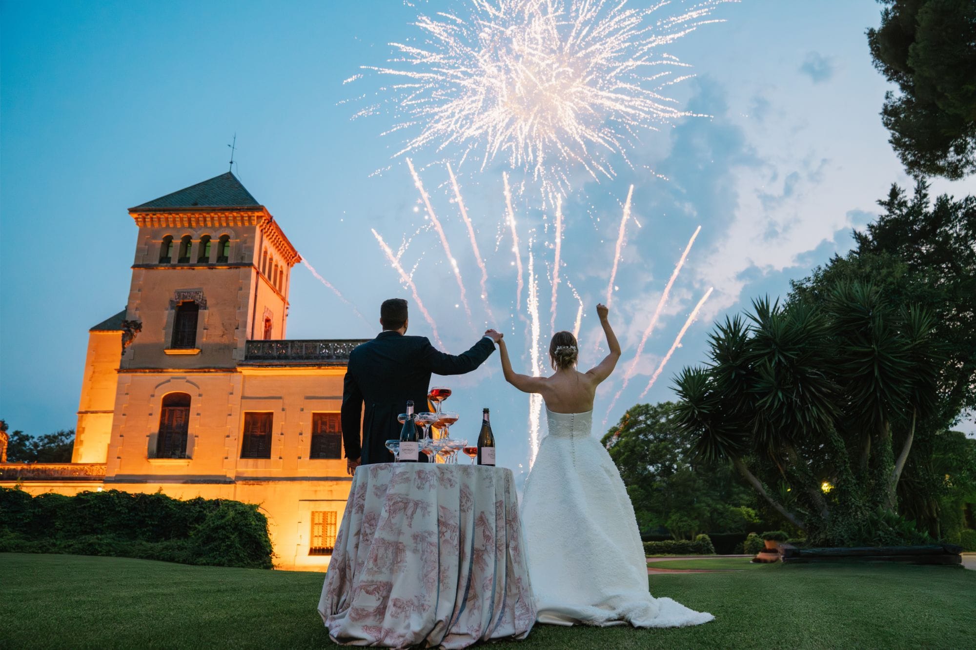 Novios mirando los fuegos artificiales frente a un castillo